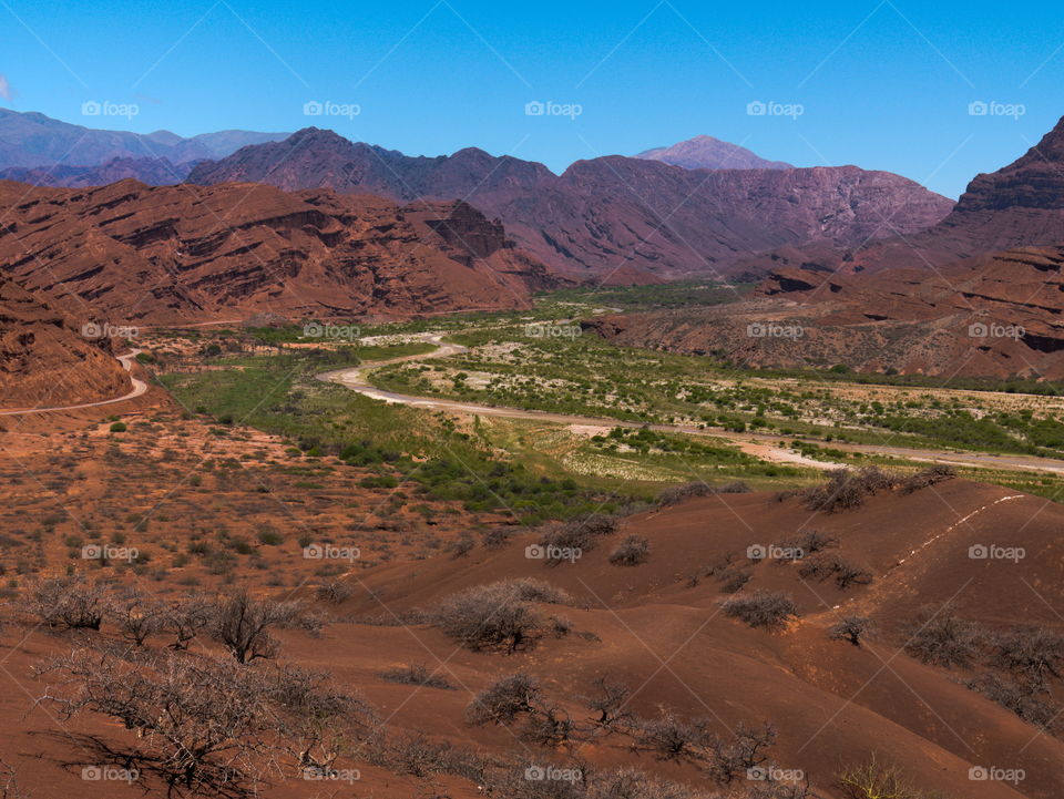 Red valley in North Argentina covered with green grass