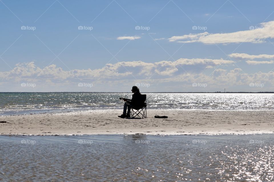 Surrounded by glistening sparkling ocean a solo singer guitarist