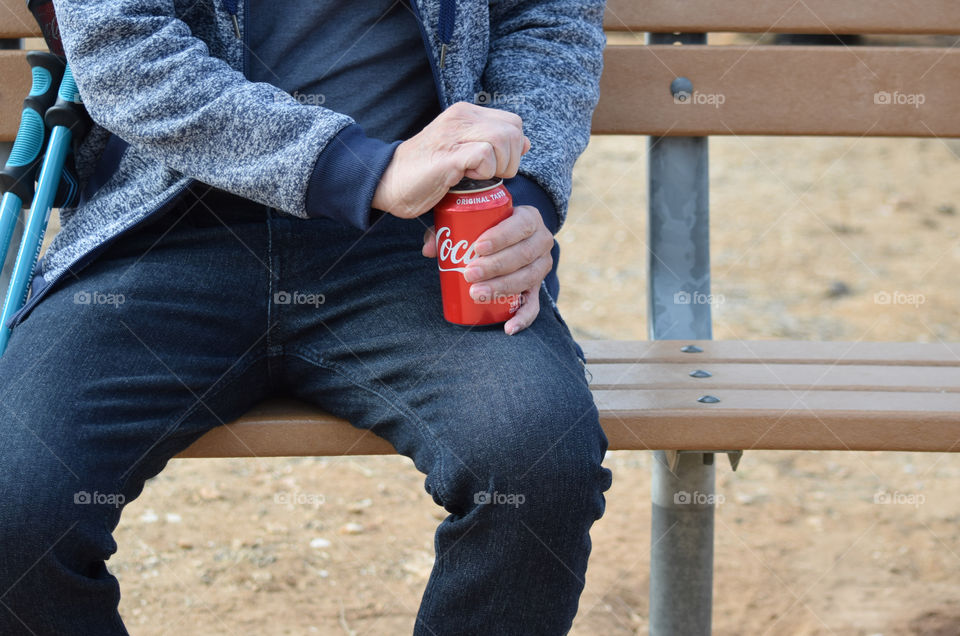 A man opening a coke in can