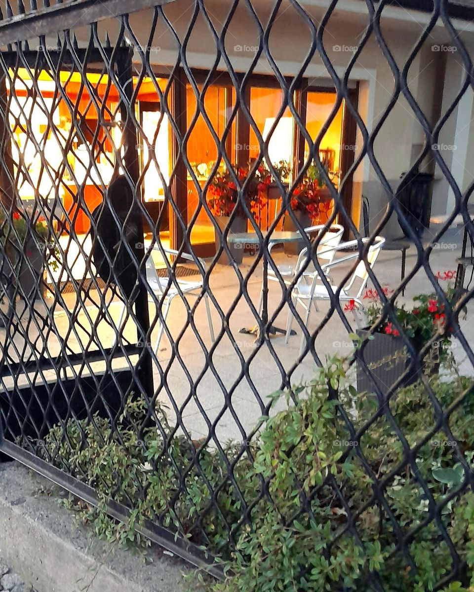 Black fence with the enterance to the ice-cream shop in the background.