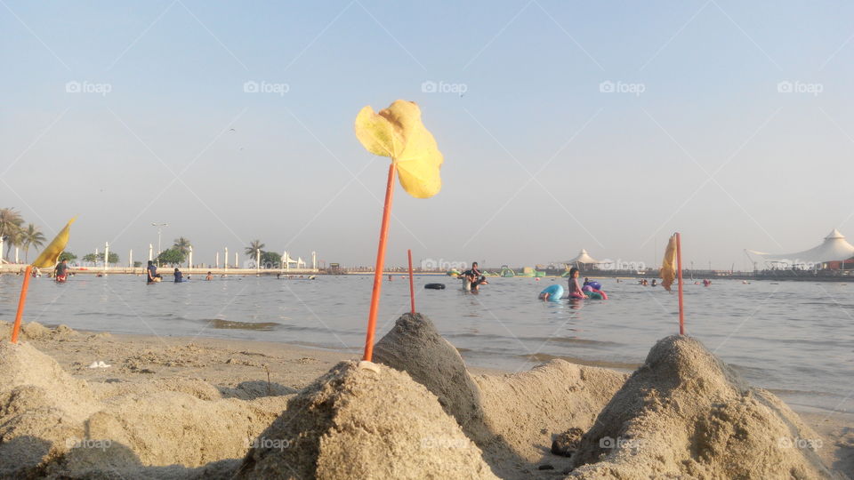 "4 Cons from Sand n Yellow foliage on the top" On Ancol Beach
