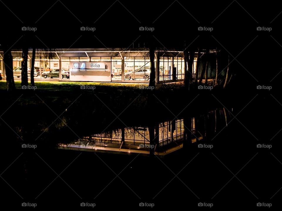 A car shop by the river into the darknes. 
Beautiful reflection into the water . 
pretty as well. .