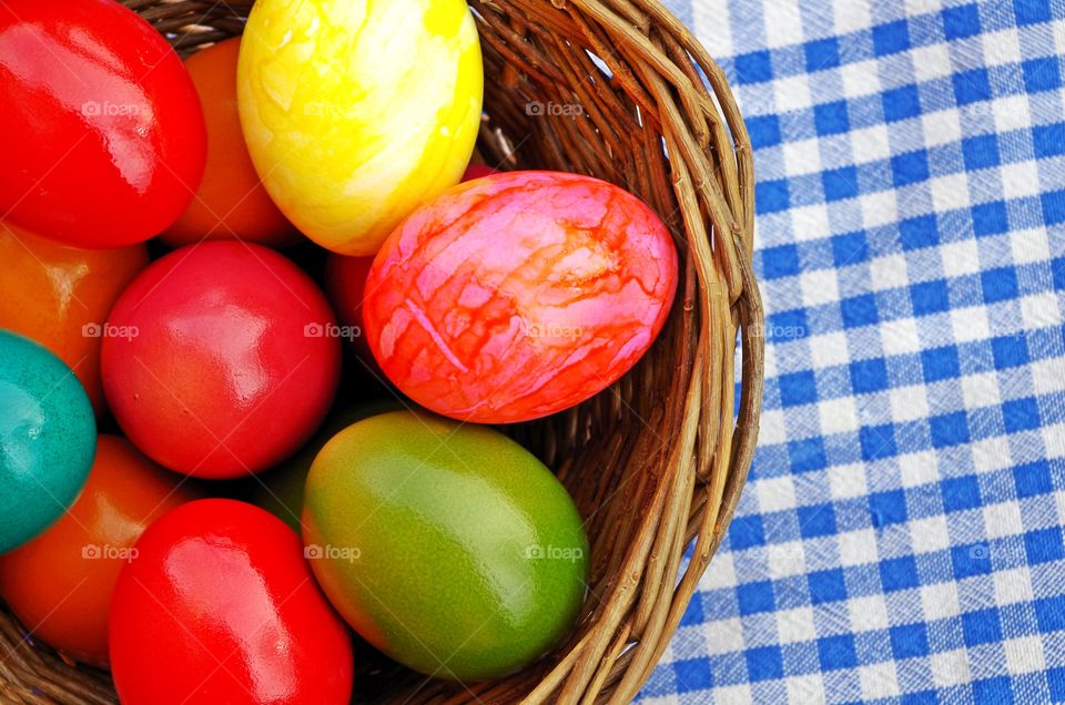 Colorful easter eggs in wicker basket