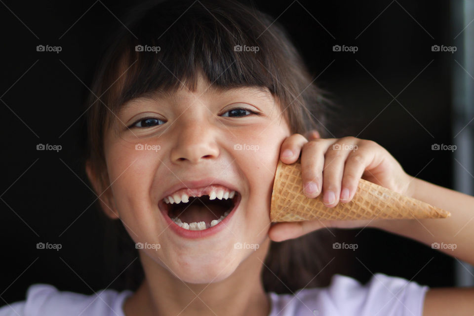 Happy girl is playing with a ice cream cone