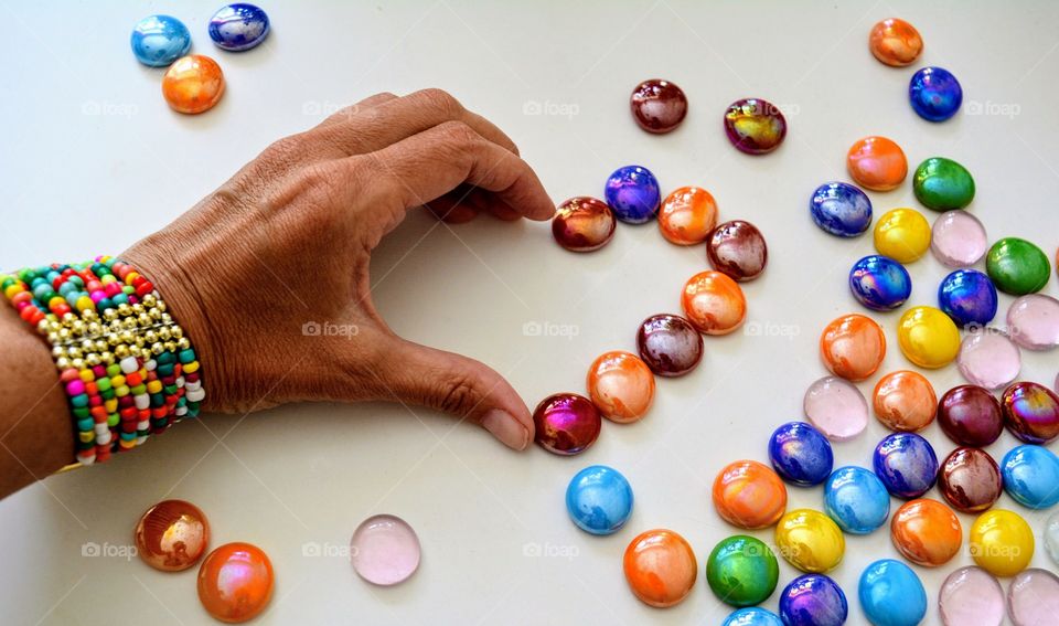 heart of the hand and colorful stones love colors on a white background