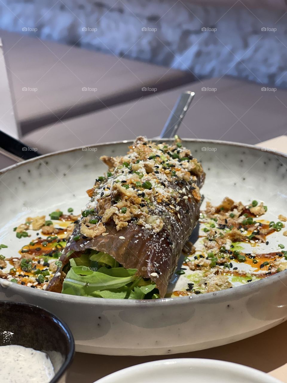 Meat carpaccio on the plate with crumbs and arugula 