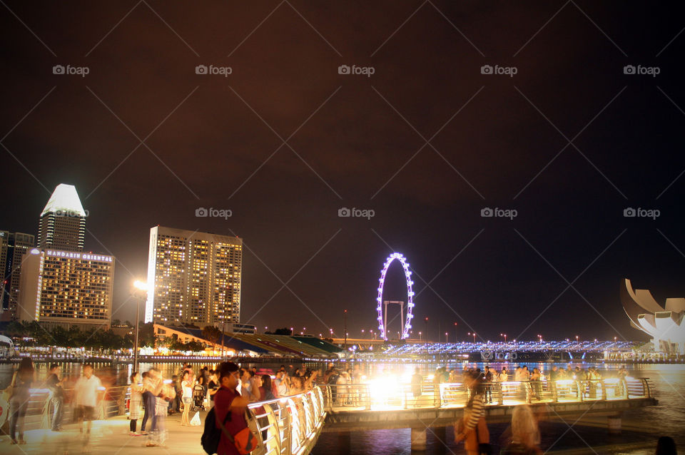 Tourists exploring the Marina Bay view deck at night