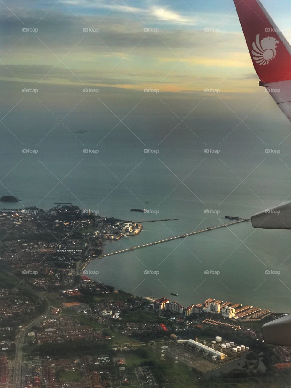 Harbour in the background and colourful cloudy evening sky makes a perfect landscape photo at above Malaysia from airplane 