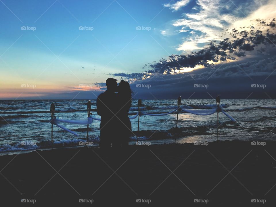 Silhouette of a Couple Embracing on the Beach Against a Beautiful Sunset