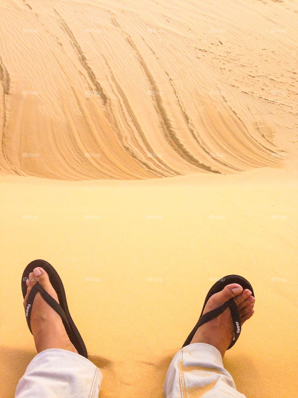 Flipflop vs sand. Sitting on the dunes in white sand dunes in Mui Ne, Vietnam