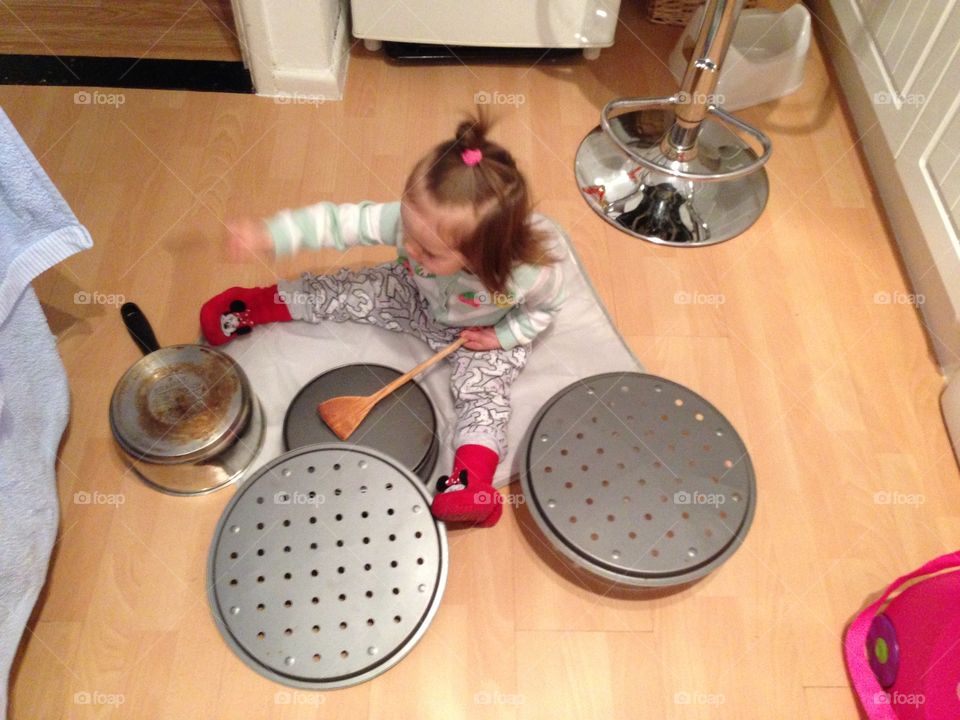 Baby playing on the hobs pots in the kitchen