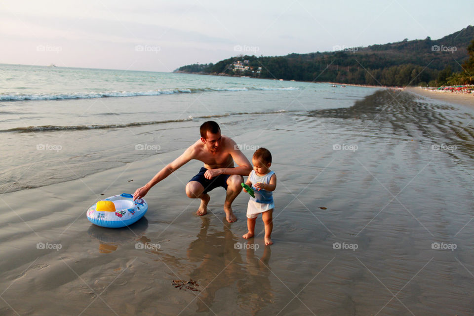 Father and his boy playing on the beach 