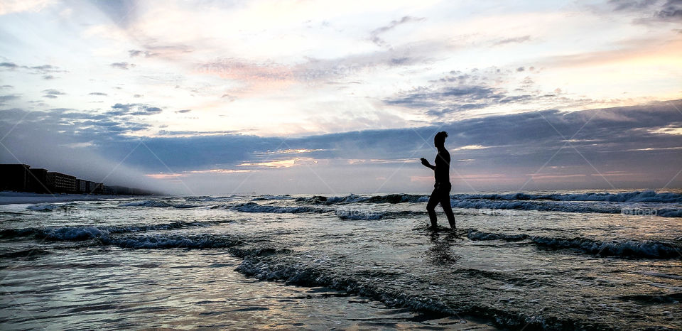young man snapping photos of sunrise.