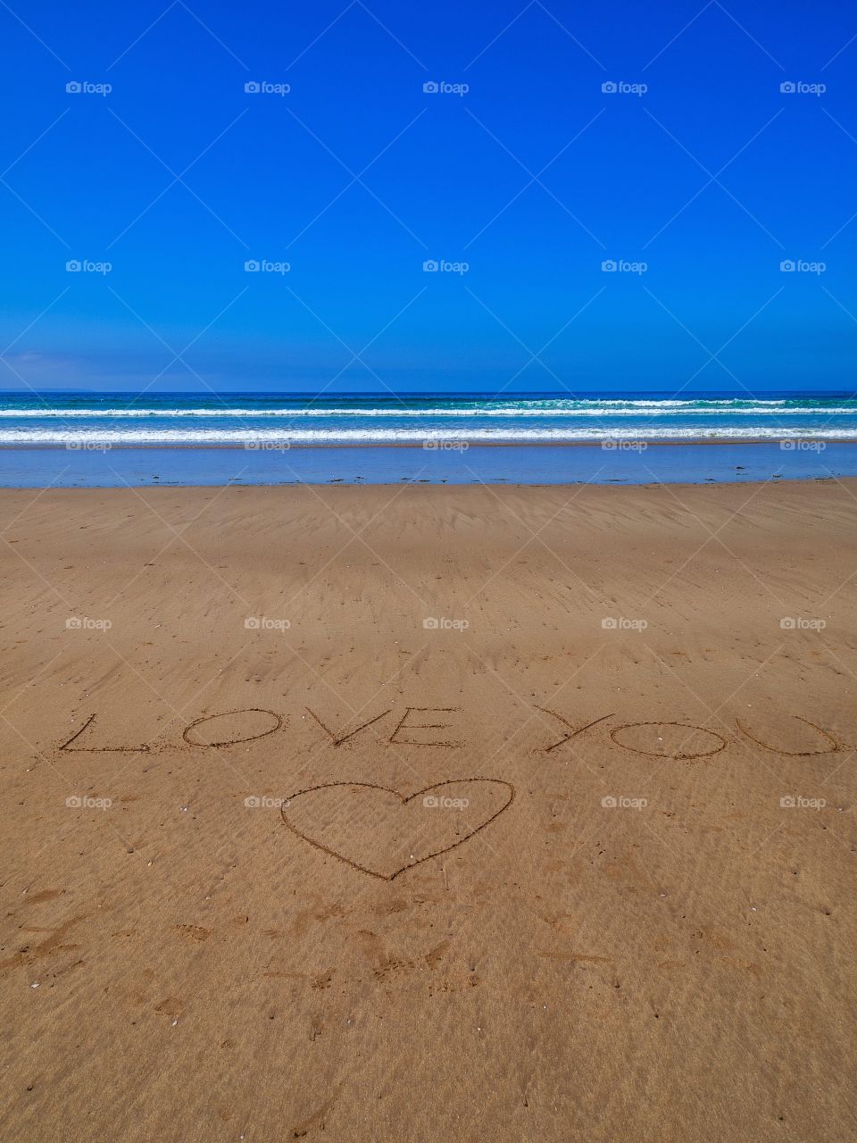 Love you text with heart shape at beach