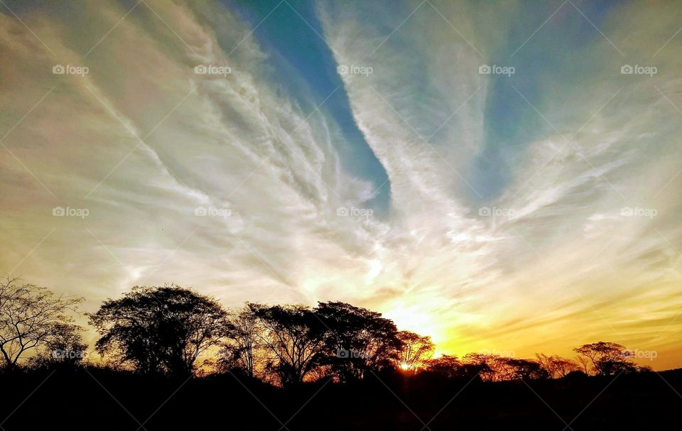 Beautiful white clouds in a blue sky framing the bright majestic sunset