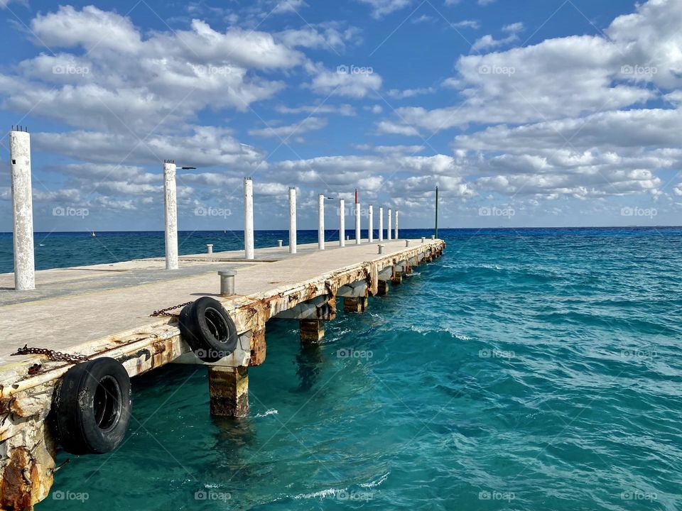 A pier extending out into beautiful blue water 