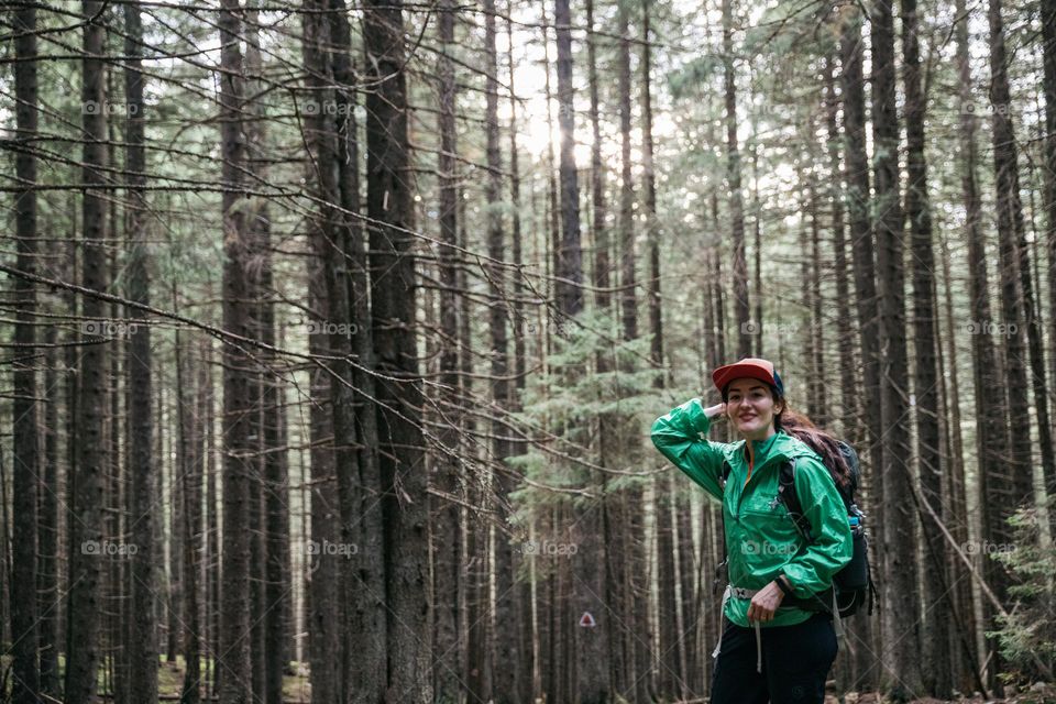 Woman being happy while on a hike in a beautiful forest.