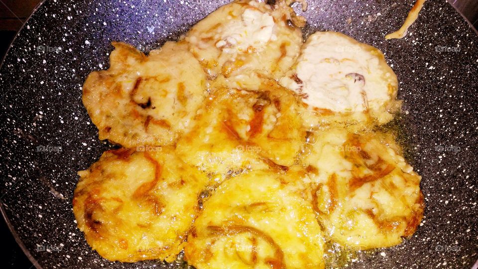 Frying frittelle with courgette flowers in the pan