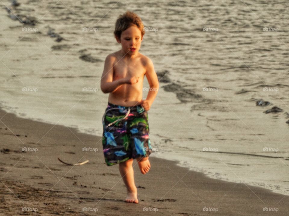 Boy Running On The Beach. Running On The Beach During The Golden Hour
