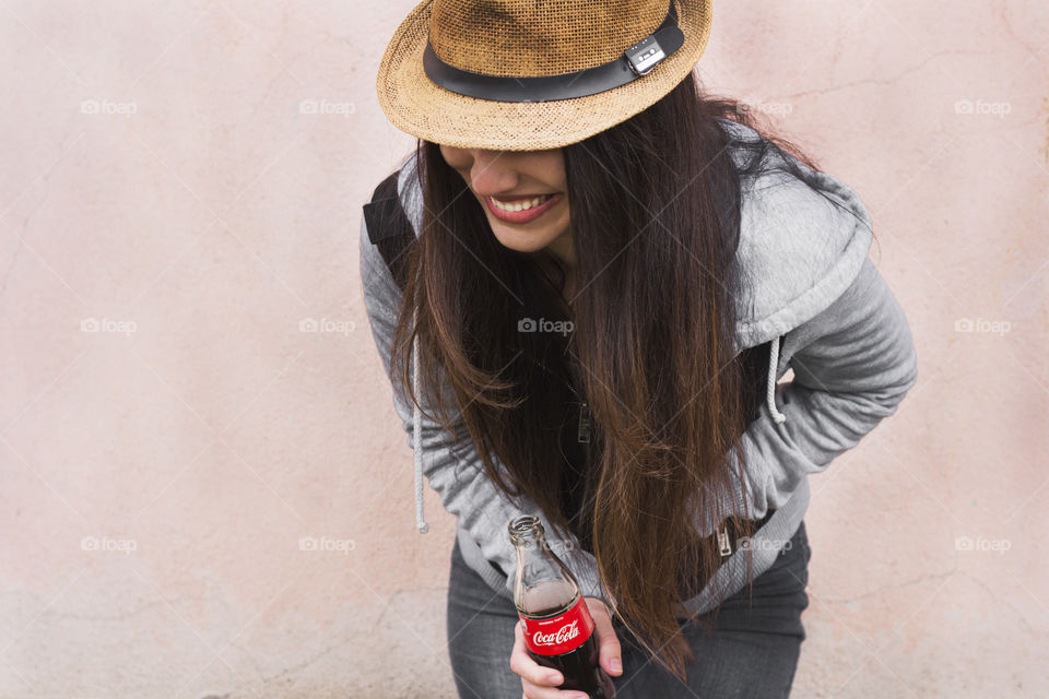 Beautiful woman holds Coca-Cola bottle and smiling