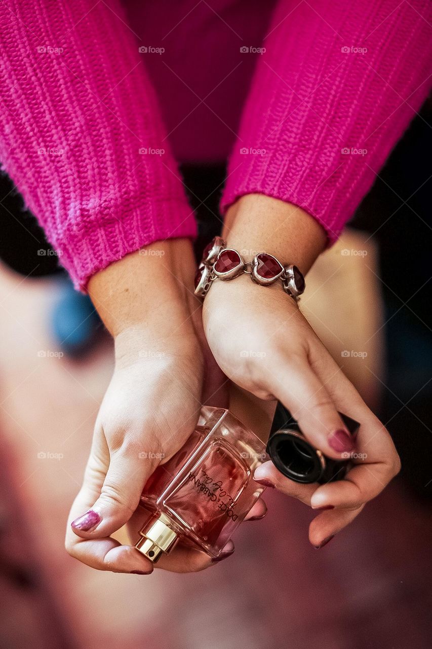 Wearing a bracelet and holding a bottle of perfume