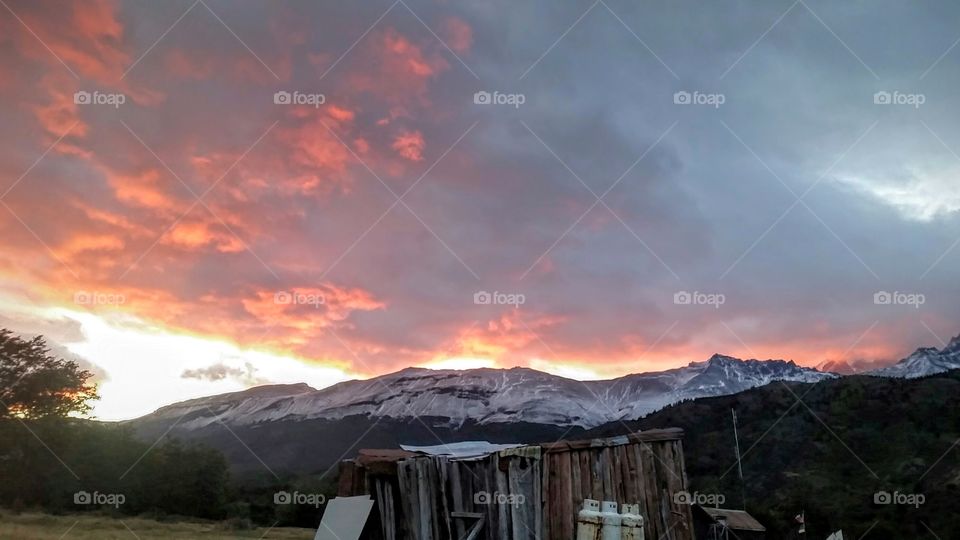 View of old wooden house against dramatic sky