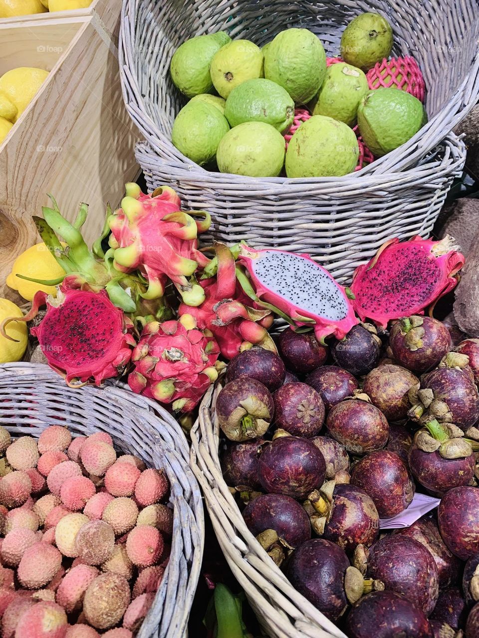 Baskets containing tropical fruit, passion fruit, dragon fruit or pitaya or strawberries pears