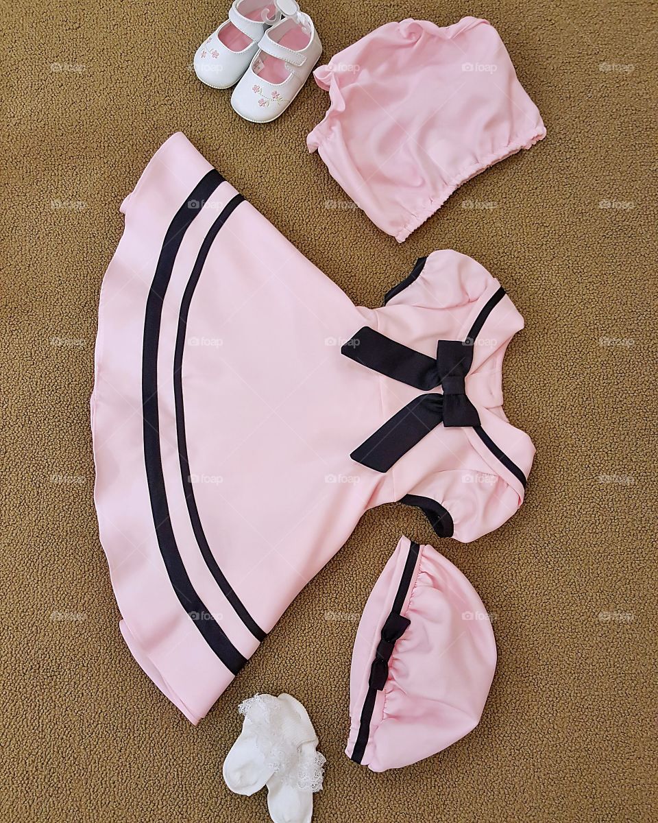 A little girls pink sailor outfit with socks and shoes.