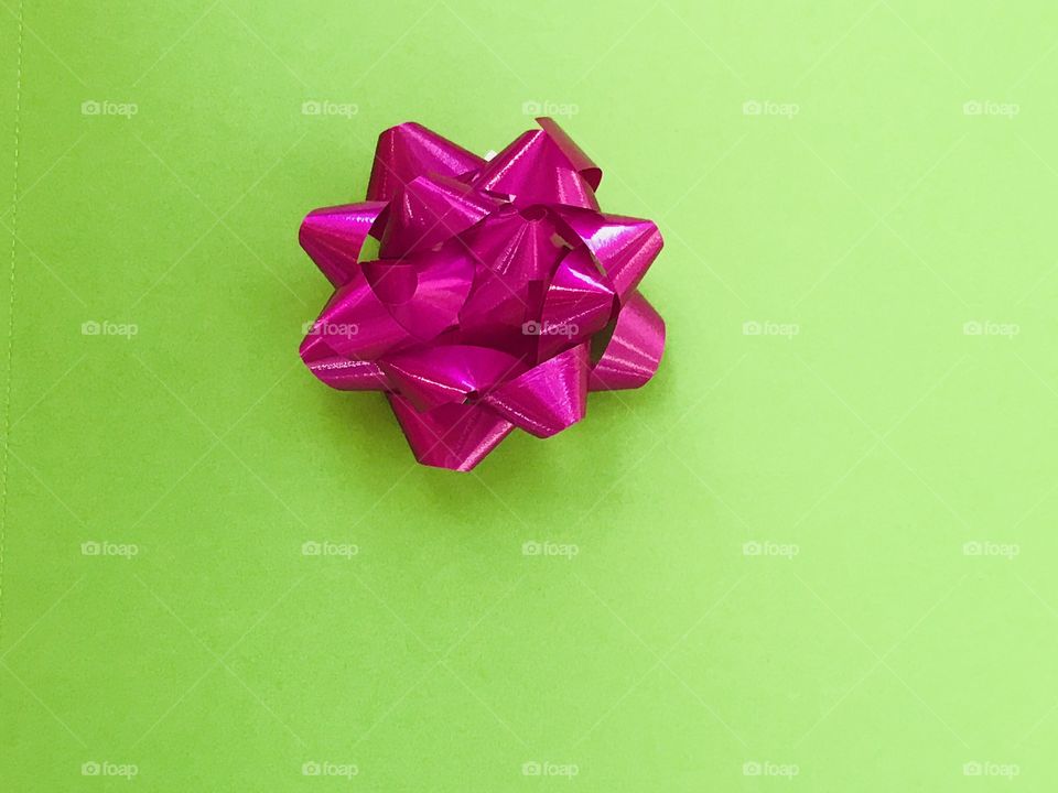 A pink bow on a green background 