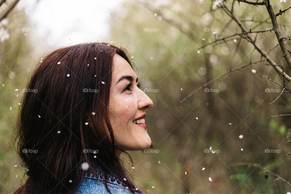 Young woman, being happy and smiling, while on a walk in nature, in spring time, on a beautiful day.