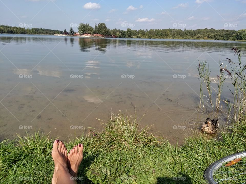 lake landscape and female legs resting summer time