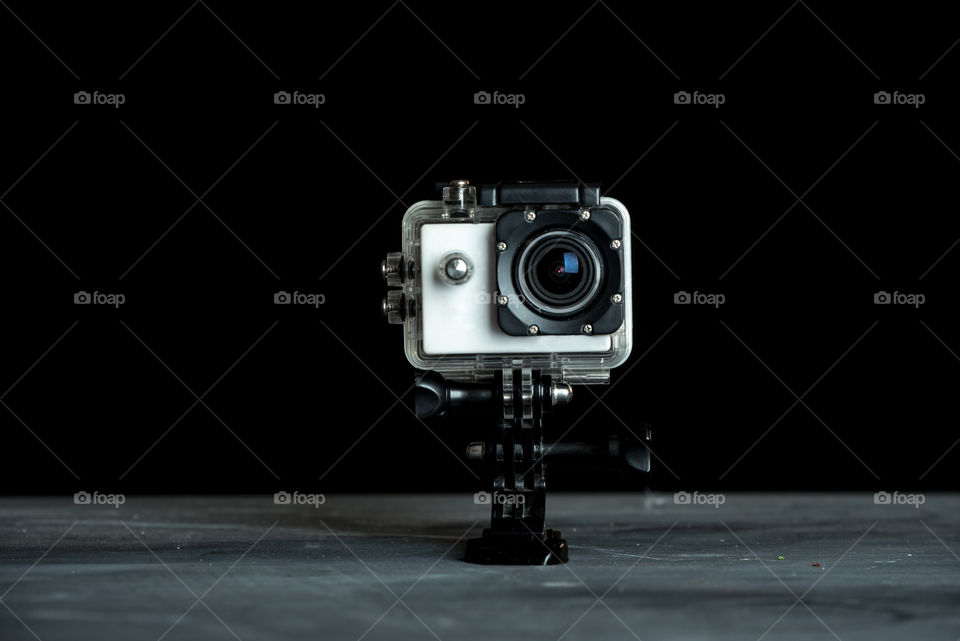 small action camera isolated on dark background as a symbol of photographic work