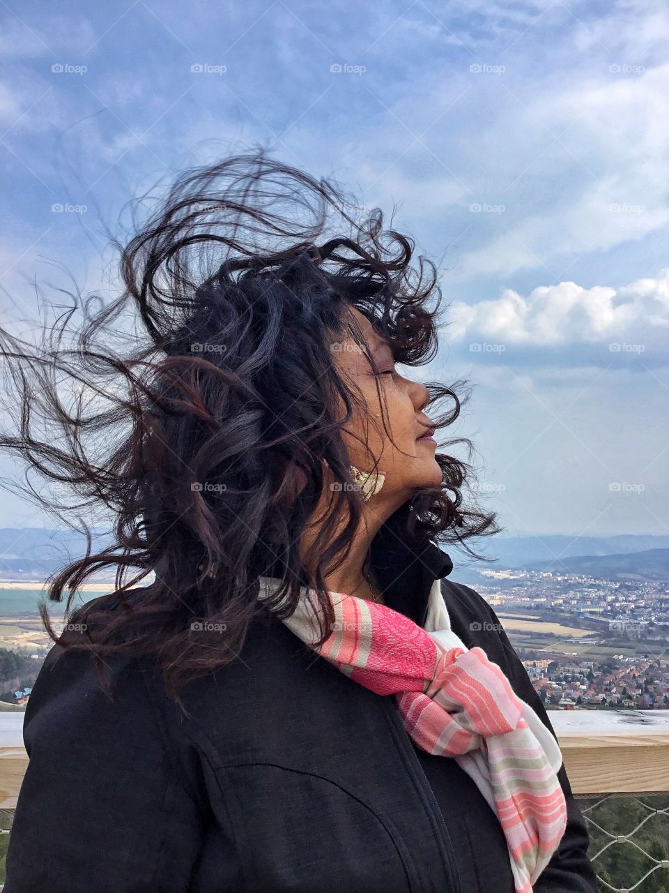 Moments freezed in photos. A beautiful lady standing on a platform high in the clouds as her hair flutters in the wind. A moment in time that you want to freeze for a lifetime