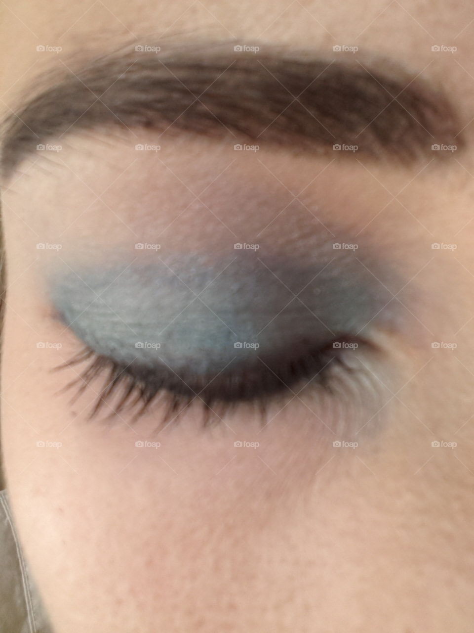 Closeup of eyelid with blue eyeshadow.