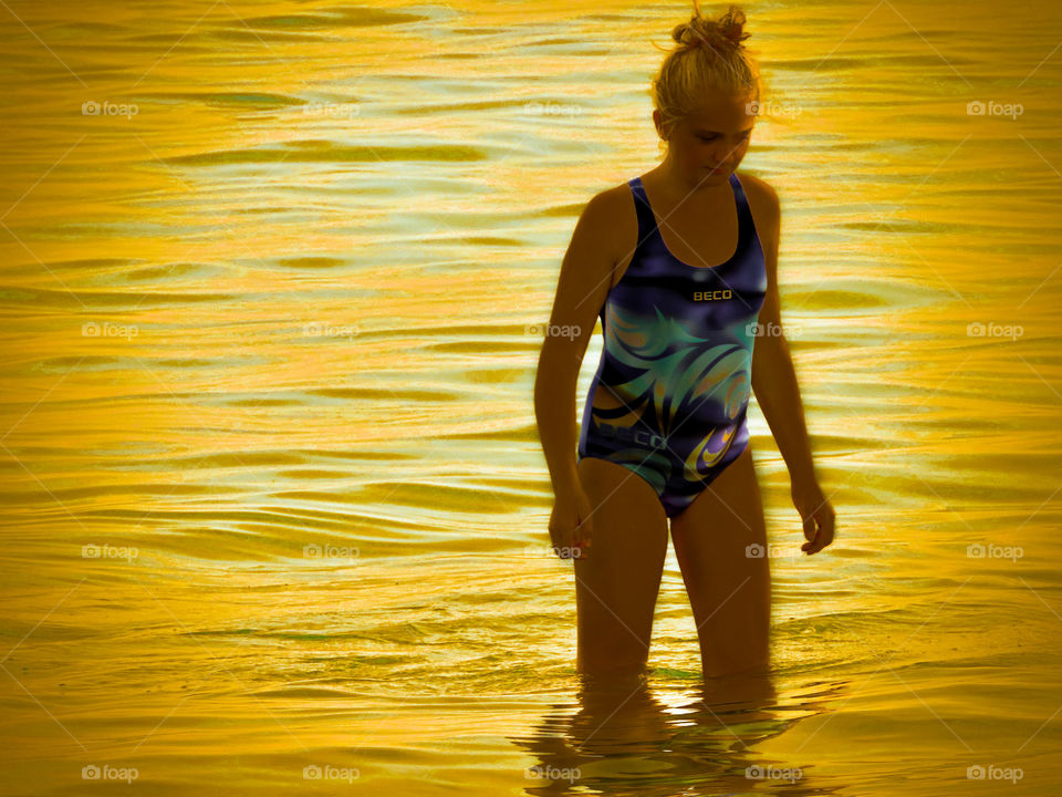 Girl standing in orange water