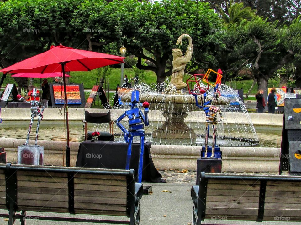 blue metal sculpture holding a red ball