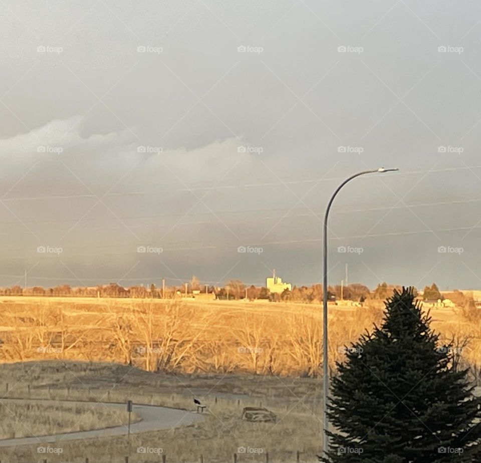 Storm clouds moving over the city in the evening, so shadow of building then prairies, then city, then skyline