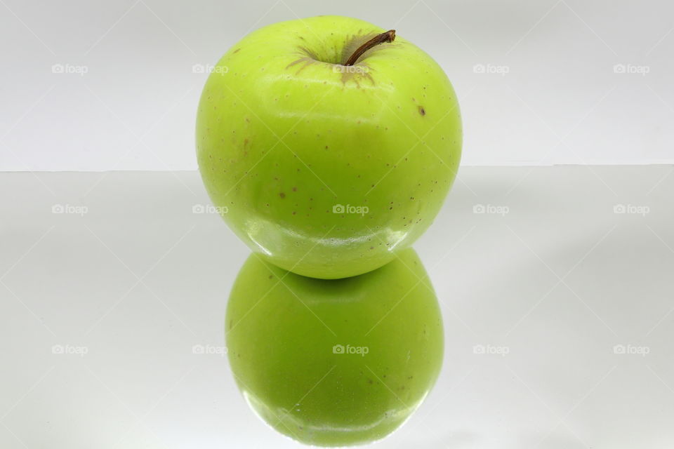 A green apple with mirror effect