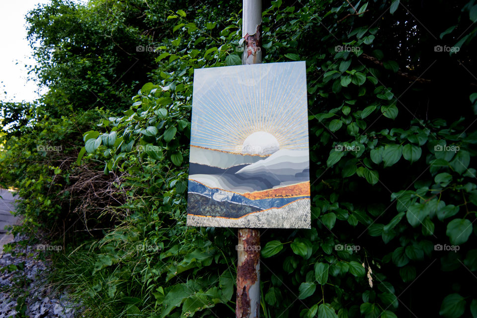 Displate in the wild - bringing nature home abstract Displate art on metal rusting pole outdoors in trees and abundant leaves 