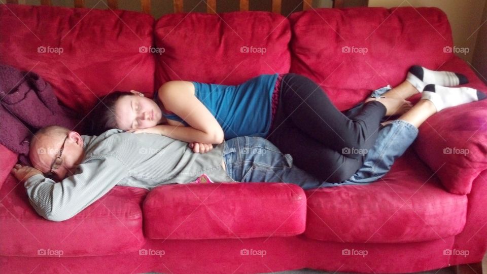 Father and daughter sleeping on sofa