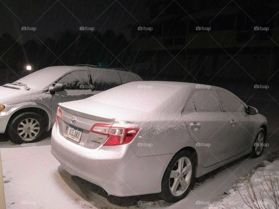 snow covered vehicles at night