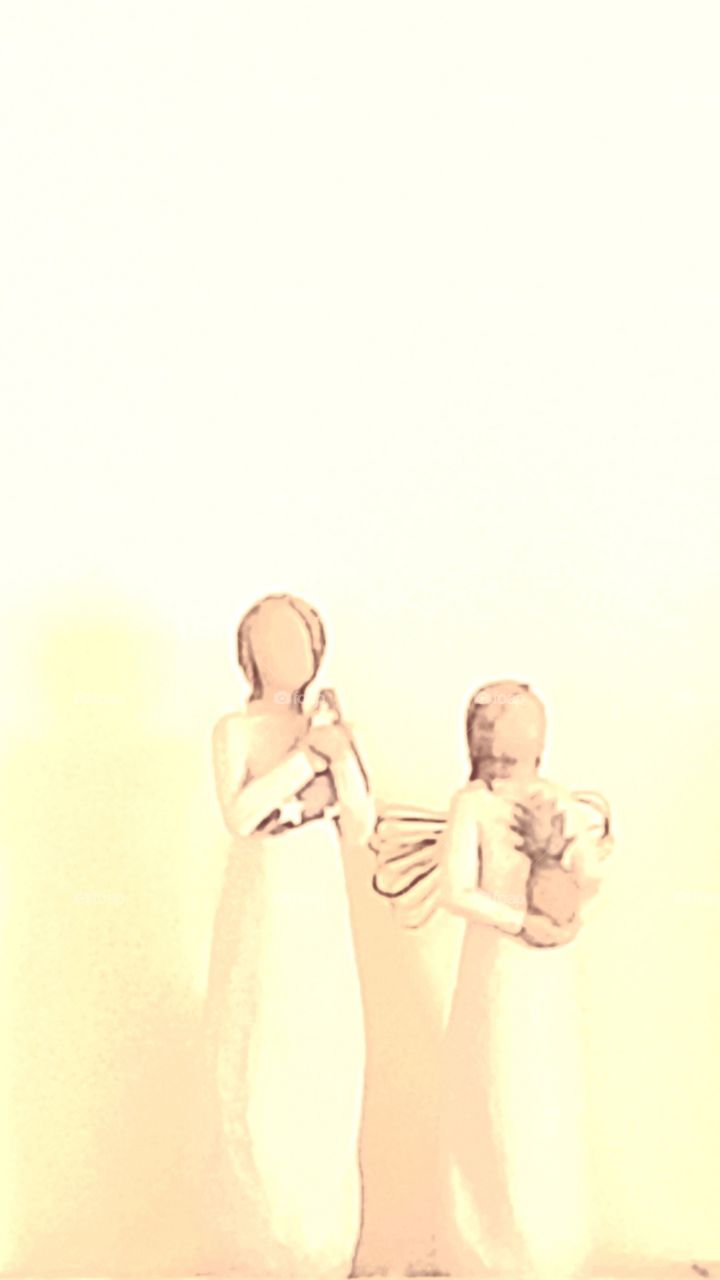 angel statues against pale yellow background foap mission minimalist