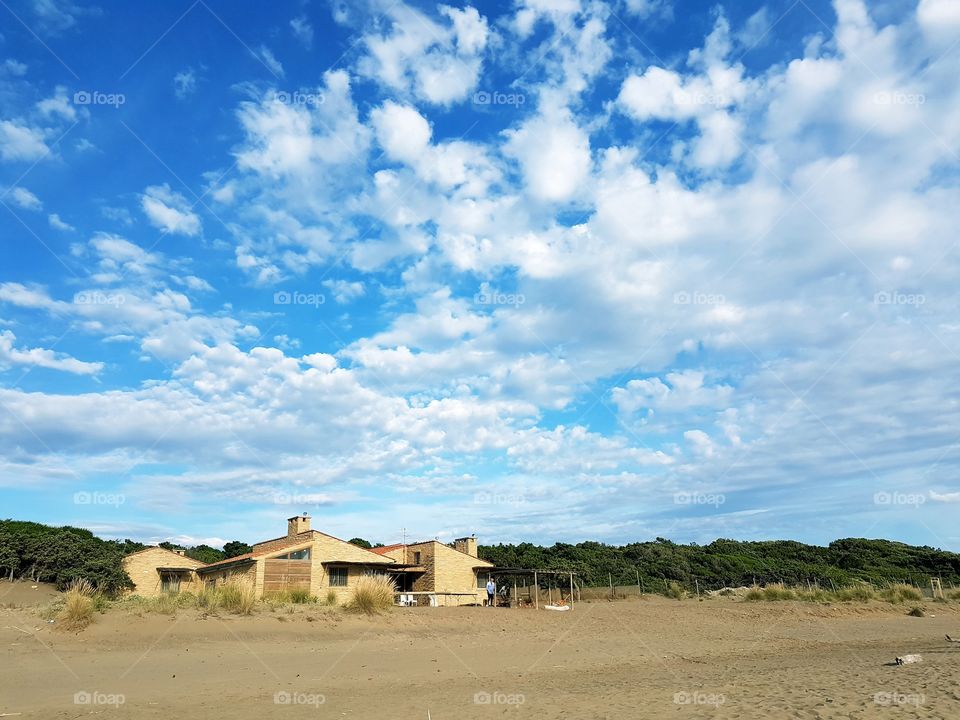 House on the sandy beach of Tuscany with blue sky