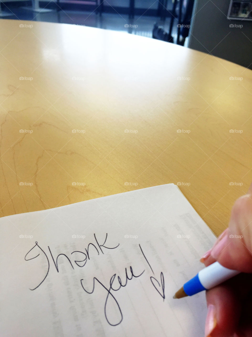 Hand writing "thank you" on white paper. Room for your text.