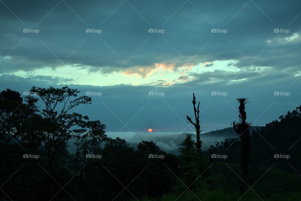 Dark horizon with blue sky and sun setting in a beautiful sunset.