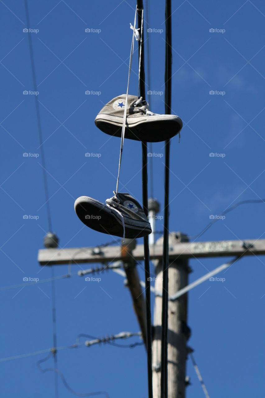 classic converse hightops dangle from the powerlines