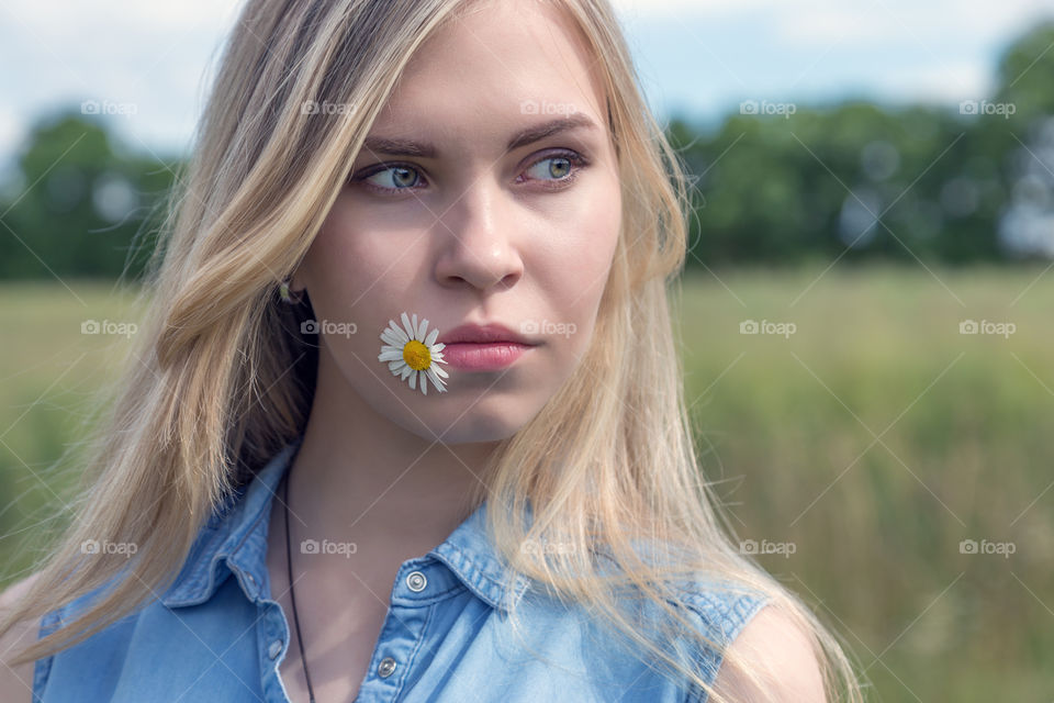 portrait a girl with daisy in her lips