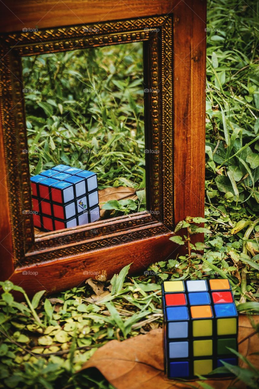 Rubik's cube disarmed and in the mirror reflects an armed cube