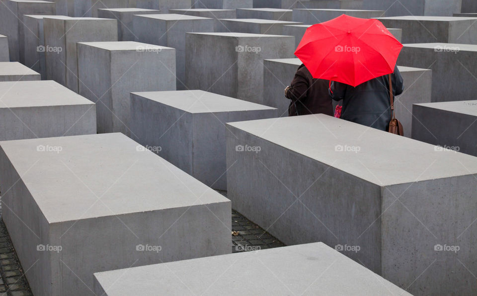 Red umbrella in grey labyrinth.