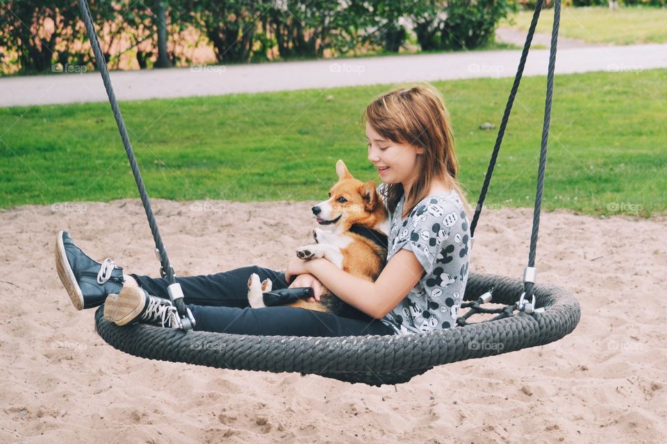 Girl and her cute dog in a swing